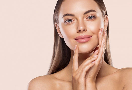 Smiling woman holding her face, showcasing radiant skin, emphasizing Hair Skin & Nail health improvements this winter.